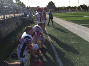 A couple of Marquette Redmen take a knee for a downed player.