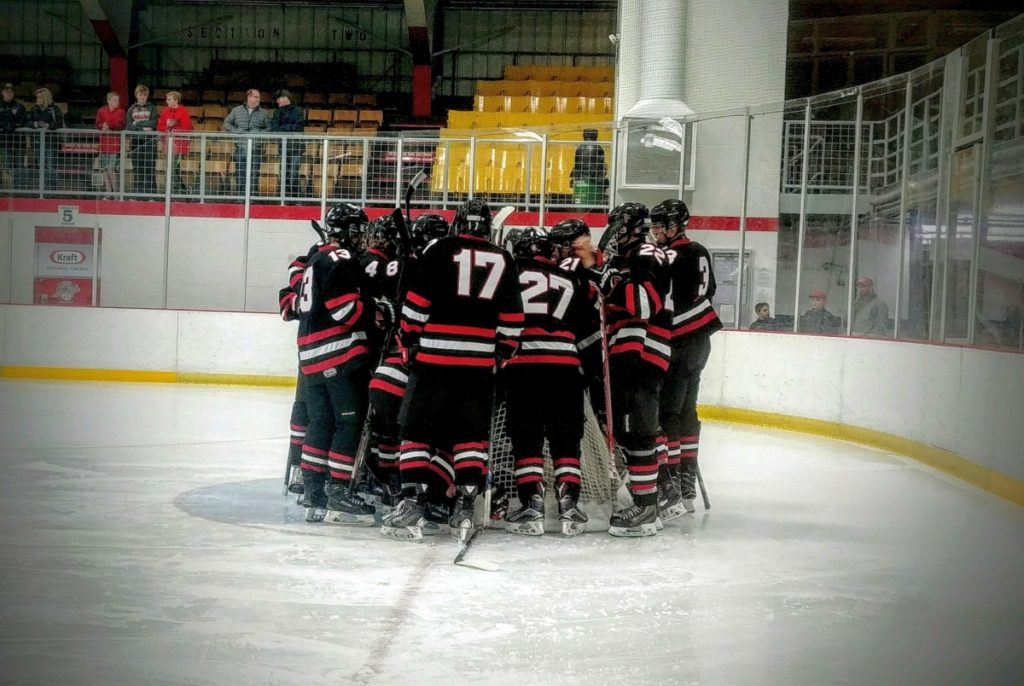 The Redmen surround their goaltender.