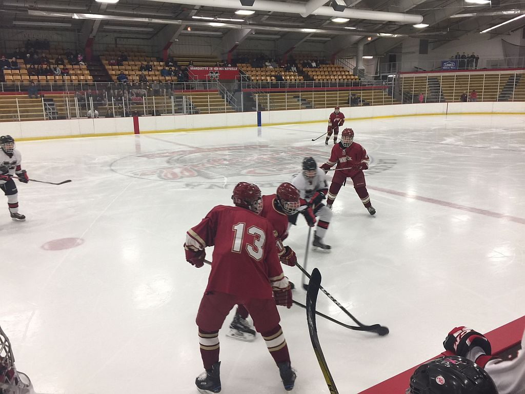 The teams battle for the puck in front of the Marquette bench