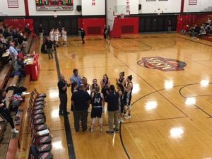 The Blue Devils gather around their coach