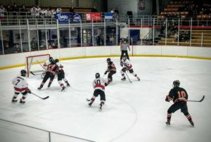 Marquette's Tanner Phillips (#10) skates with the puck in his own zone.