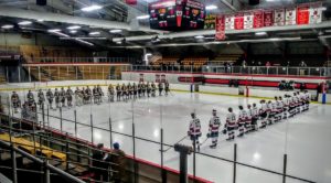 The Redmen and the Flivvers line up for the national anthem