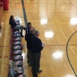 Marquette coach Ben Smith talks with Westwood coach Kurt Corcoran before the game