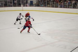 Burke takes the puck down ice before being stopped by the Pigs.