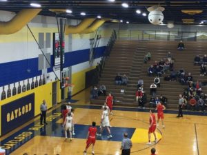 The Alpena Wildcats watch as the Marquette Redmen make a basket