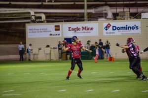 The red team's QB throwing a pass.