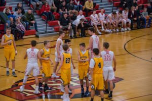 The boys meet in the middle of the court to wish each other luck.