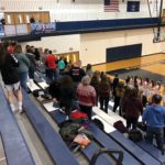 The Redettes stand for the National Anthem.