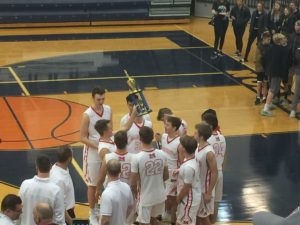 The Redmen hoist the Petoskey Invitational trophy.