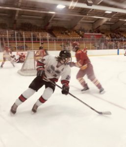 The Marquette Redmen work the puck below the red line in the Bulldogs' zone