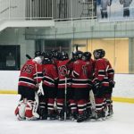 The Redmen huddle up before their bout against the Salem High School Rocks.