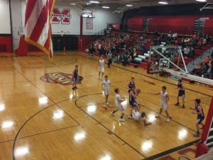 A Redmen gets knocked down at a Brave goes for the basket.