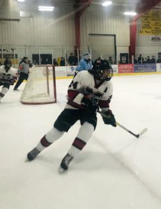The Redmen skate hard for a puck in the corner