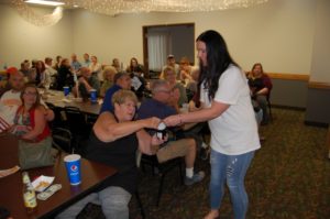 Amy delivering a door prize to a guest.