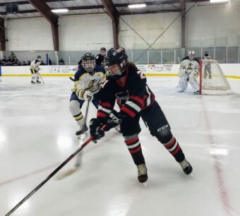 Marquette's Dylan Baldwin controls the puck in the Negaunee zone